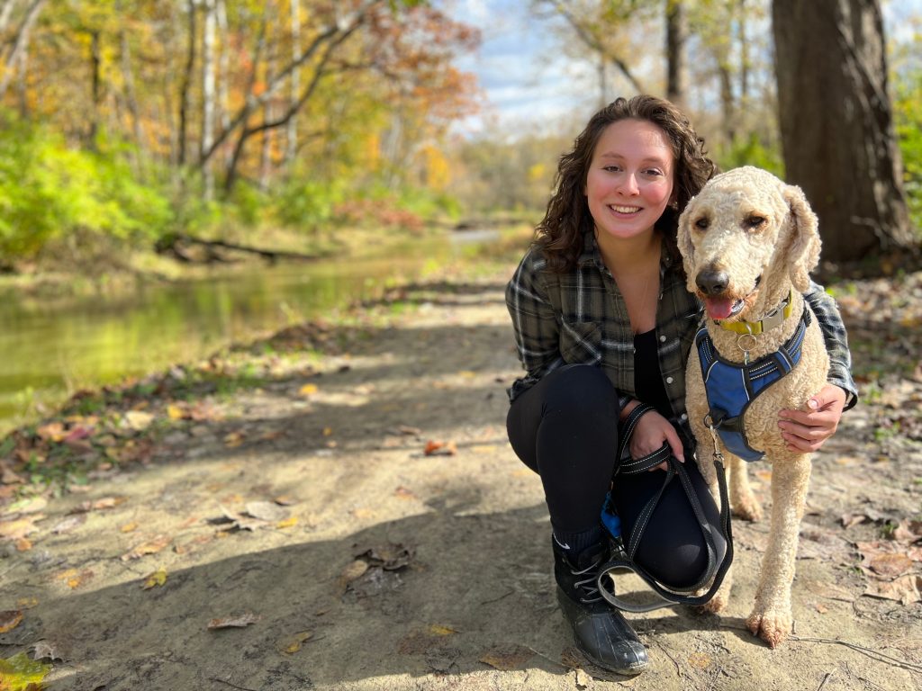 Young,Woman,And,Her,Goldendoodle,Dog,Hiking,Outdoors,On,A