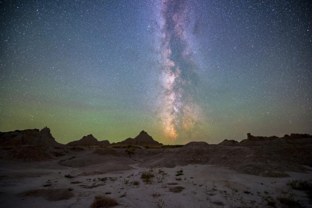 Why is the Badlands’ landscape a dramatic backdrop for stargazing?